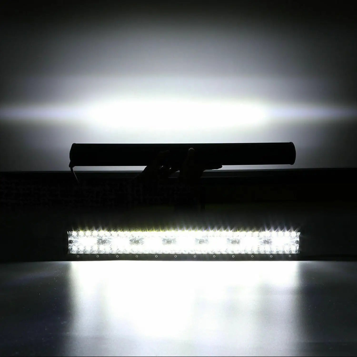 LED light bar with a black housing on a reflective surface.