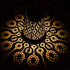 Decorative lamp casting intricate patterns on a dark background