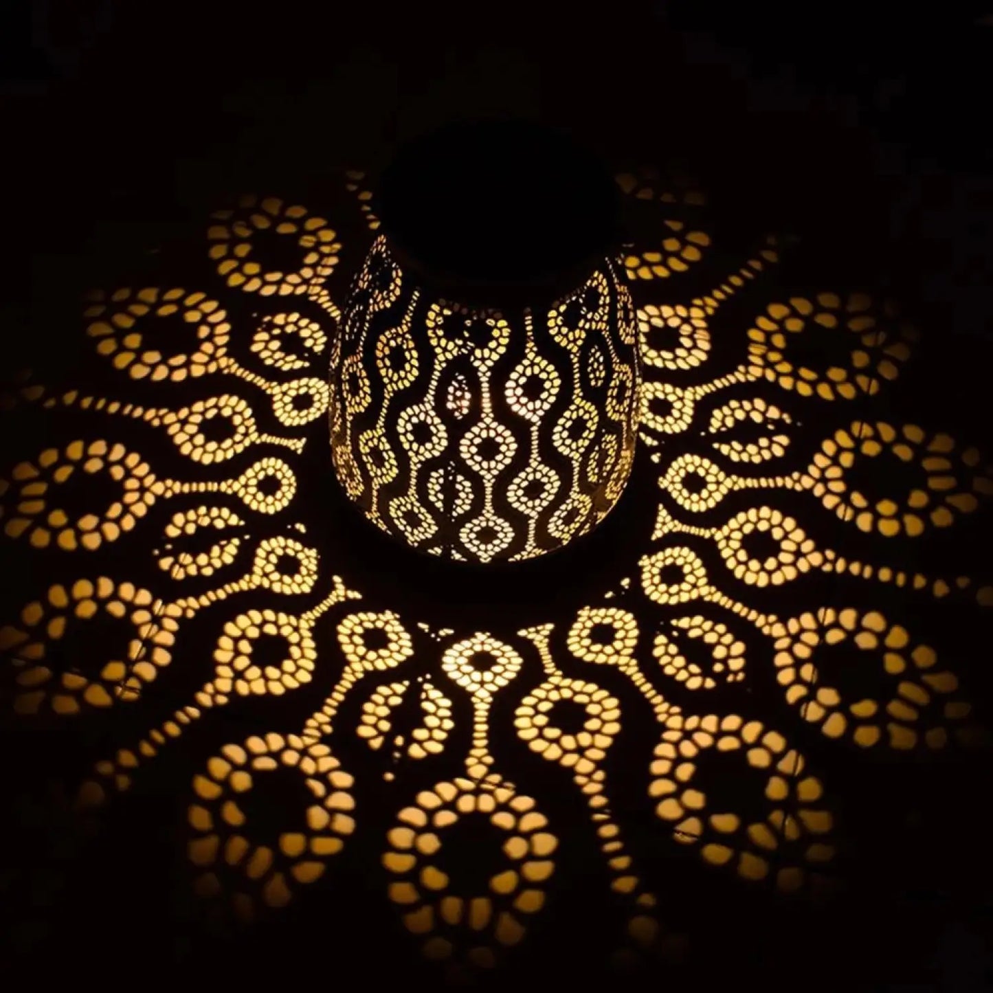 Decorative lamp casting intricate patterns on a dark background