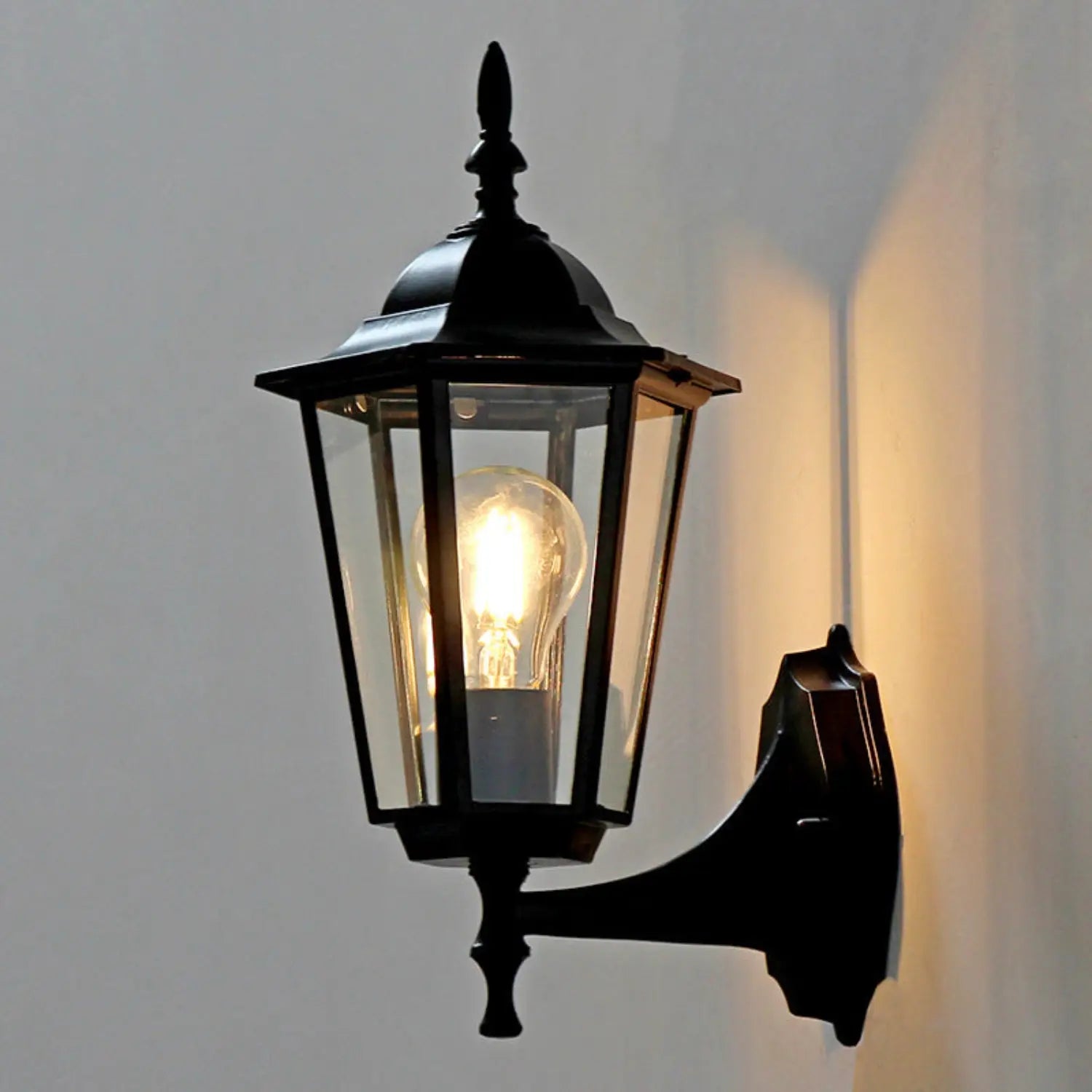 Black outdoor wall light fixture on a gray wall